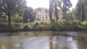A ruined grand home across the river